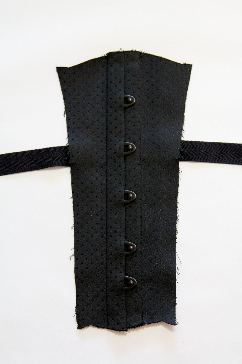 A corset busk inserted into spot coutil © Amy Earl
